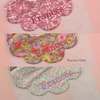 Set of three pink-tone Liberty scalloped baby bibs, shown with personalised monogramming