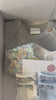 Baby gift box that includes baby socks with Liberty London bows, Scalloped baby bib in Michelle blue print, grey knitted set of top and leggings.